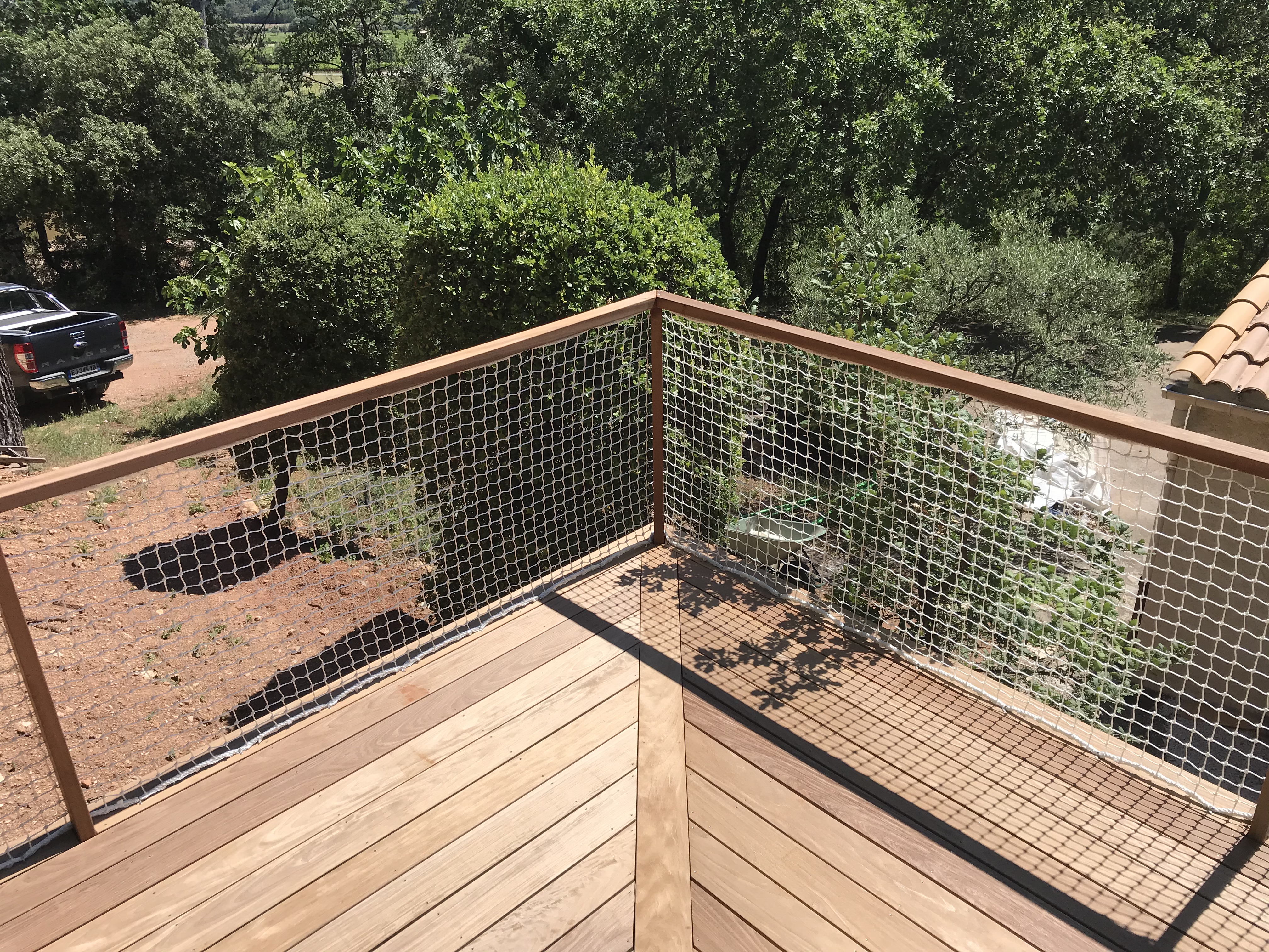 Terrasse en bois exotique sur mesure en haute sur pilotis avec garde corps sur mesure en bois et filet made in France. La Motte 83920 Paysagiste